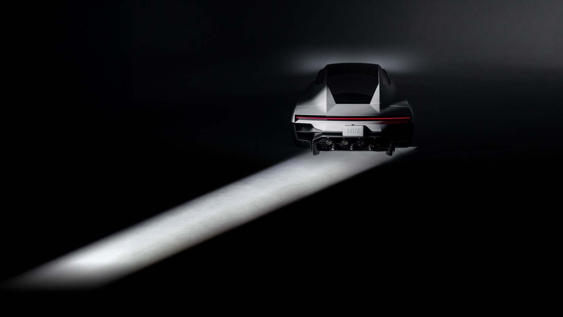 Le nouveau Tesla Roadster vu de l'arrière, éclairé par un faisceau de lumière dans un studio sombre