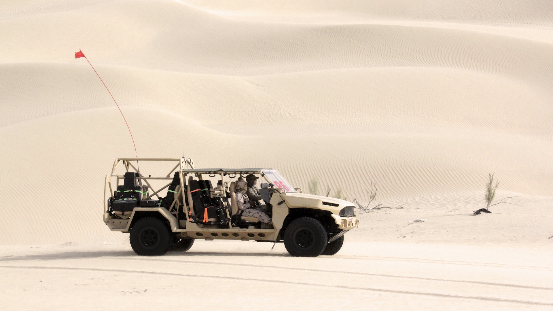 Side view of GM Defense’s Infantry Squad Vehicle driving on sand at UAE Armed Forces Summer Trials