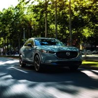 Mazda CX-30 2022 gris, vue trois-quarts avant en conduite dans une rue bordée d'arbres | Mazda Canada Mazda CX-30 2022 gris, vue trois-quarts avant en conduite dans une rue bordée d'arbres