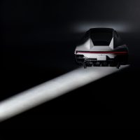 Tesla Roadster, vue arrière dans un faisceau de lumière | Tesla Le nouveau Tesla Roadster vu de l'arrière, éclairé par un faisceau de lumière dans un studio sombre