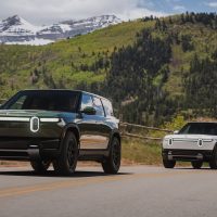 Deux Rivian R2 de série, vert foncé et blanc, lors des essais routiers pour les médias en Utah en mai 2026 | Rivian Deux Rivian R2 de série, l'un vert foncé et l'autre blanc, roulant sur une route de montagne en Utah