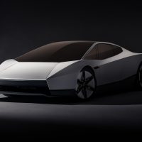 Tesla Roadster, vue trois-quarts avant | Tesla Tesla Roadster blanc vu de trois-quarts avant, toit vitré teinté, sur fond sombre