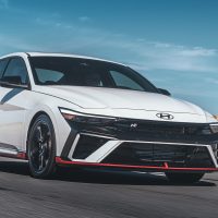 Elantra N 2024 blanche, vue trois-quarts avant en conduite | Hyundai Elantra N 2024 blanche, vue trois-quarts avant en conduite