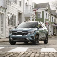 Kia Seltos 2024 restylé, en bleu Pluton, à un passage pour piétons | Kia Kia Seltos 2024 bleu Pluton vu de face dans une rue résidentielle