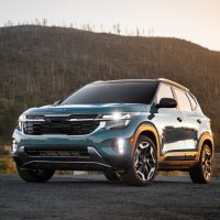Kia Seltos 2025, vue avant trois quarts au coucher du soleil | Kia Kia Seltos 2025 bleu vu de l'avant trois quarts devant des collines