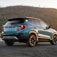 Kia Seltos 2025, vue arrière trois quarts avec les feux du restylage | Kia Arrière du Kia Seltos 2025 bleu vu de trois quarts