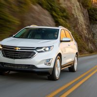 Equinox 2018 blanc Summit White, vue trois-quarts avant en conduite sur la route | GM Canada Equinox 2018 blanc Summit White, vue trois-quarts avant en conduite sur la route