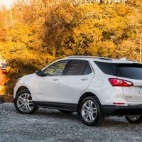 Equinox 2018 blanc Premier AWD, vue trois-quarts arrière près d'un pont couvert | GM Canada Equinox 2018 blanc Premier AWD, vue trois-quarts arrière près d'un pont couvert