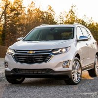 Equinox 2018 blanc, vue trois-quarts avant en forêt à l'heure dorée | GM Canada Equinox 2018 blanc, vue trois-quarts avant en forêt à l'heure dorée
