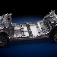 Rendu structurel de la plateforme de VÉ de quatrième génération de GM, bâtie autour de la batterie LMR et conçue pour les segments à plus fort volume. | Photo: General Motors Rendu de la structure d’une plateforme de véhicule électrique, avec plancher, berceaux avant et arrière et quatre roues, sur fond bleu foncé