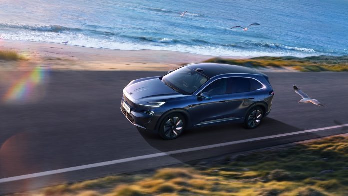 Buick Electra E7 bleu foncé roulant sur une route en bord de mer